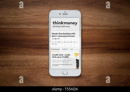 Un iPhone montrant le Thinkmoney site web repose sur une table en bois brut (usage éditorial uniquement). Banque D'Images