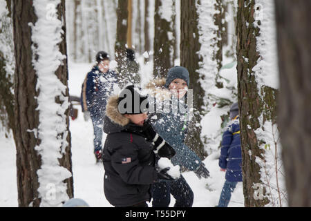 Le Bélarus, la ville de Gomel, le 23 décembre, 2017. Village de la forêt. La maison de vacances de Noël. Les garçons la neige rejetée à l'autre. Boules de jouer Banque D'Images