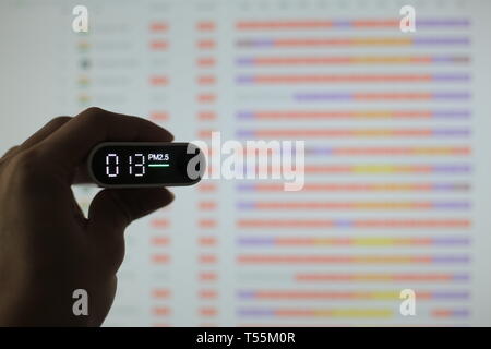 Mesurer la qualité de l'air. les particules (PM 2.5.2.5) capteur dans une main. petit détecteur de poussières nuisibles a indiqué la qualité de l'air acceptable en bonne santé. blur ba Banque D'Images