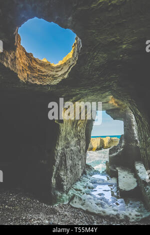 Torre dell'Orso, Italie. 30Th Oct, 2017. La côte Adriatique de Salento est riche en grottes et ravins creusés dans les siècles passés par des pêcheurs qui avaient besoin d'un abri contre le mauvais temps. Ces grottes sont encore visibles et peuvent être explorés dans de nombreux domaines entre San Cataldo et Otrando. Cette vue de la mer est pris de l'intérieur de l'une de ces anciennes habitations dans la ville de Roca Vecchia, un important site archéologique dans la région de Salento. Credit : Luigi Rizzo/Pacific Press/Alamy Live News Banque D'Images