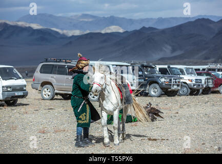 Bayan Ulgii, Mongolie, 3 octobre 2015 : kazakh man in traditional pardessus et chapeau avec son cheval dans un parking dans la nature Banque D'Images