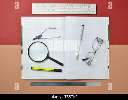 Un grand carnet pour Notes et rédaction avec modèle d'objets pour un étudiant. Règle, marqueur, crayon, loupe, boussoles, verres. Vue d'en haut. Banque D'Images