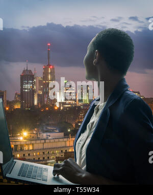 Businesswoman holding laptop par ville au coucher du soleil à Nairobi, Kenya Banque D'Images