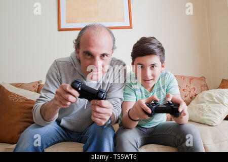 Père et fils adolescent playing video game Banque D'Images