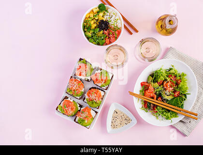 Petit déjeuner sain. Bol Bouddha avec le riz, la mangue, l'avocat et le saumon et salade de tomates, d'avocat, roquette, saumon, graines et sandwich au saumon Banque D'Images