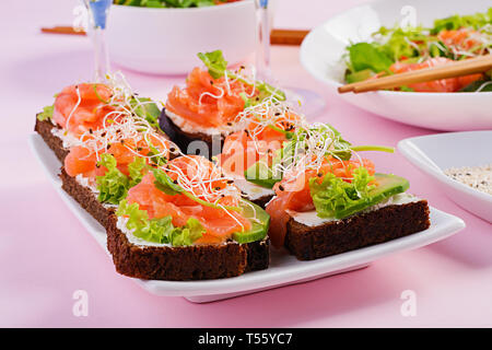 Saumon en sandwich avec du fromage à la crème et microgreen. Canape avec le saumon. Banque D'Images