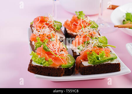 Saumon en sandwich avec du fromage à la crème et microgreen. Canape avec le saumon. Banque D'Images