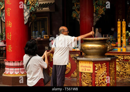 Thaïlande, Bangkok, Chinatown, Thanon Yaowarat, Kuan Yim culte, l'homme et de la femme en prière avec d'encens Banque D'Images