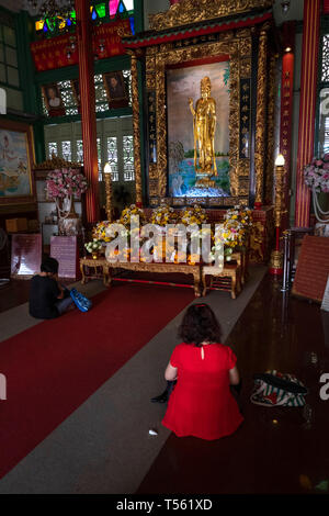 Thaïlande, Bangkok, Chinatown, Thanon Yaowarat, Kuan Yim culte, adorateurs, agenouillée à 900 ans Guan Yin statue dorée Banque D'Images