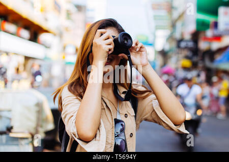 Young Asian Woman Woman holding a camera et prendre des photos à Bangkok, Thaïlande lors d'un voyage en Asie du sud-est Banque D'Images