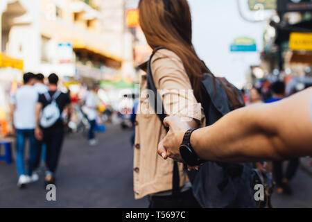 Jeune amie holding hand de petit ami. Backpacker touristiques en train de marcher dans la rue du marché ensemble à Bangkok, Thaïlande. Suivez-moi concept Banque D'Images