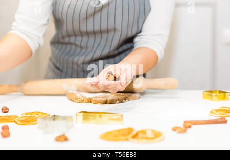 Jeune jolie femme prépare la pâte et cuit le pain d'épices et des biscuits dans la cuisine. Joyeux Noël et Bonne Année. Banque D'Images