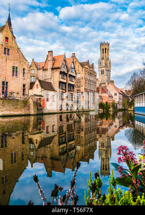 Paysage avec célèbre beffroi et bâtiments médiévaux le long d'un canal de Bruges, Belgique Banque D'Images