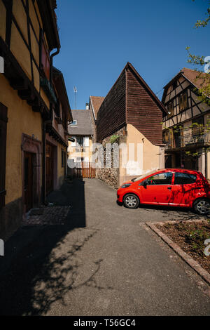 Bergheim, France - 19 Avril 2019 : Peugeot rouge voiture garée en face de cour traditionnelle dans le centre de l'Alsace, dans le charmant village de Bergheim Banque D'Images