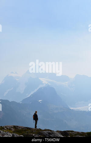 Femme est au sommet de la montagne à la fin d'une longue randonnée Banque D'Images