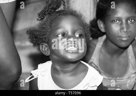 CUBA LA HAVANE - le 7 juillet 2012 ; image monochrome Afro-Cuban fille sur la porte avec une sœur sur rue en souriant et heureux jusqu'à la recherche. Banque D'Images