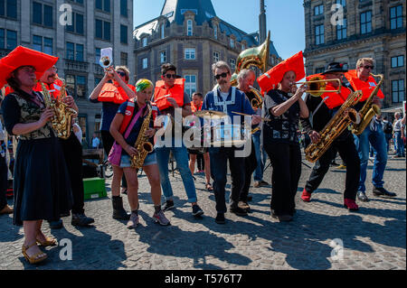 Amsterdam, Pays-Bas. Apr 21, 2019. Un orchestre vu jouer de la musique avant les allocutions.Des centaines de personnes rassemblées autour de la Place du Dam à la demande au gouvernement néerlandais de laisser le Sea-Watch 3 (un bateau qui a été le sauvetage des réfugiés à la mer Méditerranée) continuer à faire son travail. Créer une route sûre pour les réfugiés, pour arrêter le commerce des armes et aussi pour les politiciens à Amsterdam qu'ils devraient rouvrir l'abri d'hiver et d'établir un refuge d'urgence pour les réfugiés sans papiers et les sans-abri. Credit : ZUMA Press, Inc./Alamy Live News Banque D'Images