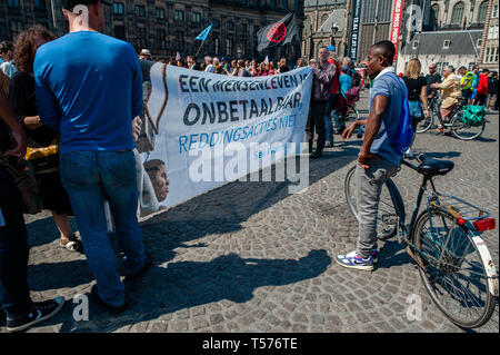 Amsterdam, Pays-Bas. Apr 21, 2019. Les protestataires sont vues tenant une bannière le démonstration.Des centaines de personnes rassemblées autour de la Place du Dam à la demande au gouvernement néerlandais de laisser le Sea-Watch 3 (un bateau qui a été le sauvetage des réfugiés à la mer Méditerranée) continuer à faire son travail. Créer une route sûre pour les réfugiés, pour arrêter le commerce des armes et aussi pour les politiciens à Amsterdam qu'ils devraient rouvrir l'abri d'hiver et d'établir un refuge d'urgence pour les réfugiés sans papiers et les sans-abri. Credit : ZUMA Press, Inc./Alamy Live News Banque D'Images