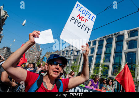 Amsterdam, Pays-Bas. Apr 21, 2019. Un manifestant est vu scandant des slogans tout en tenant une pancarte qui dit aux gens de ne pas but lucratif pendant la manifestation.Des centaines de personnes rassemblées autour de la Place du Dam à la demande au gouvernement néerlandais de laisser le Sea-Watch 3 (un bateau qui a été le sauvetage des réfugiés à la mer Méditerranée) continuer à faire son travail. Créer une route sûre pour les réfugiés, pour arrêter le commerce des armes et aussi pour les politiciens à Amsterdam qu'ils devraient rouvrir l'abri d'hiver et d'établir un refuge d'urgence pour les réfugiés sans papiers et les sans-abri. Credit : ZUMA Press, Inc. Banque D'Images