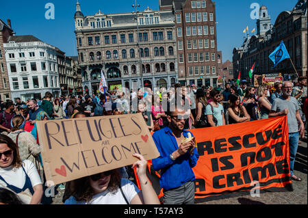 Amsterdam, Pays-Bas. Apr 21, 2019. Les protestataires sont vus holding a placard et la bannière lors de la manifestation. Des centaines de personnes rassemblées autour de la Place du Dam pour exiger le gouvernement néerlandais laissez le Sea-Watch 3 (un bateau qui a été le sauvetage de réfugiés dans la Méditerranée) continuer à faire son travail. Ils ont également appelé à pour les politiciens à Amsterdam pour rouvrir l'abri d'hiver et d'établir un refuge d'urgence pour les réfugiés sans papiers et les sans-abri. Credit : SOPA/Alamy Images Limited Live News Banque D'Images