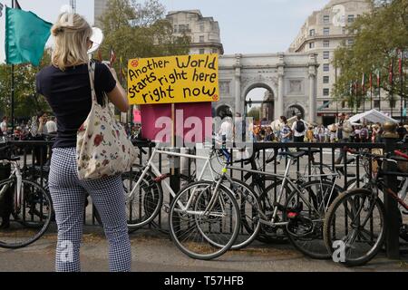 (190422) -- Londres, 22 avril 2019 (Xinhua) -- une femme prend une photo d'un signe au cours de la démonstration du changement climatique du Marble Arch à Londres, Grande-Bretagne, le 22 avril 2019. Organisé par l'extinction des manifestants rassemblés ici pour rébellion lundi pour exiger des mesures sur le changement climatique. (Xinhua/Tim Ireland) Banque D'Images