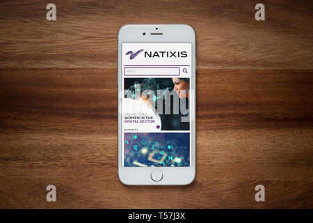 Un iPhone montrant le site web de Natixis repose sur une table en bois brut (usage éditorial uniquement). Banque D'Images