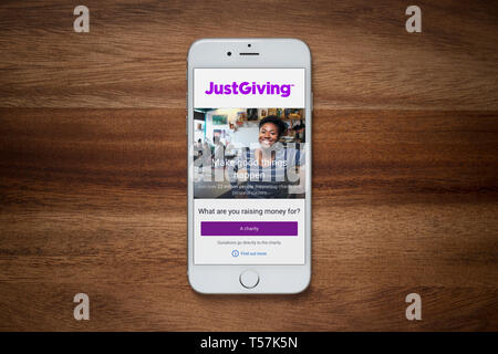 Un iPhone montrant le site JustGiving repose sur une table en bois brut (usage éditorial uniquement). Banque D'Images