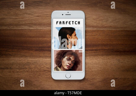 Un iPhone montrant le site Farfetch repose sur une table en bois brut (usage éditorial uniquement). Banque D'Images