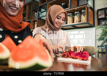 Femme musulmane ami préparer quelques fruits cocktail dessert Banque D'Images