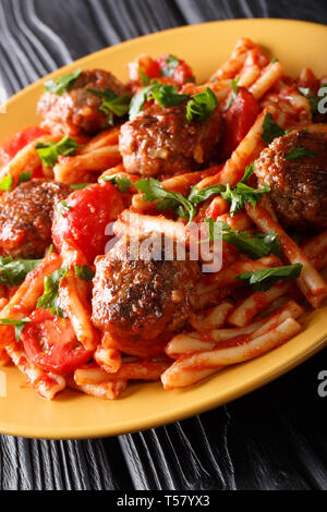 Servir les pâtes casarecce avec boulettes de viande assaisonnée à la sauce tomate sur une plaque verticale sur la table. Banque D'Images