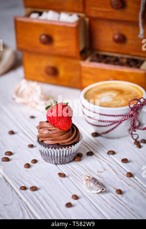 Gâteau au chocolat avec des fraises et un verre sur la table. Banque D'Images