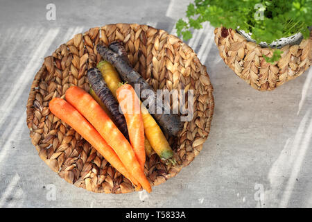 Les carottes colorées, jaune, orange et violet. Panier de légumes sur un compteur de cuisine