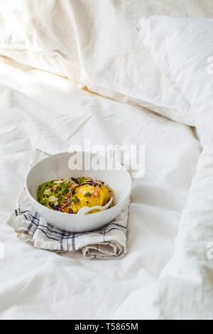 Barres granola avec de l'avocat, de l'air, les petits fruits et les fruits dans un bol blanc. Régime alimentaire à base de plantes concept. Banque D'Images