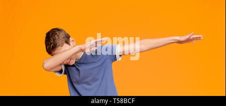 Teen boy throwing dab propose, sur fond orange Banque D'Images