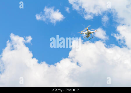 Bourdon blanc quad copter avec appareil photo numérique haute résolution volant dans le ciel bleu Banque D'Images