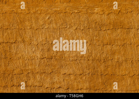 Mur de plâtre sale jaune et gris, avec écailles de peinture tombant. Surface rugueuse. Banque D'Images