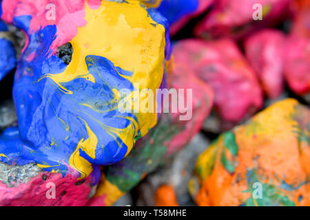 Rochers couverts de peinture colorée close-up. Des pierres dans la peinture avec des stries. Abstract background Banque D'Images