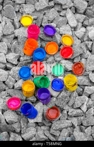 Petits pots de couleur de la peinture peut se coucher sur un caillou gris close-up Banque D'Images