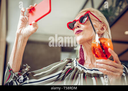 Nice agréable woman looking at her smartphone Banque D'Images
