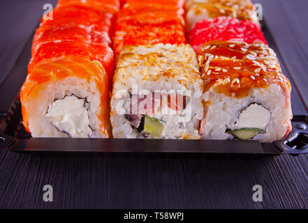 Différents types de sushis servis sur table noire Banque D'Images