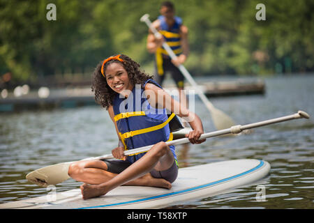 Portrait d'une jeune femme assise sur un paddleboard. Banque D'Images