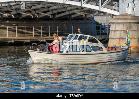 Les amis profitez de la fin de l'après-midi soleil sur un petit bateau par pont Djurgården à Stockholm Banque D'Images