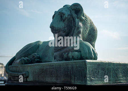 L'un des deux lions en bronze égyptien qui sont assis de chaque côté du pont Norrbro (Nord). Datant de 1926, la base est inscrit avec hiéroglyphes. Banque D'Images