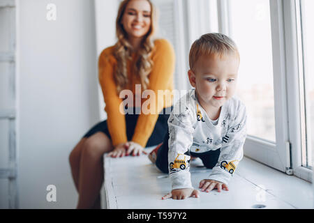 Mère assis à la maison avec peu de fils Banque D'Images