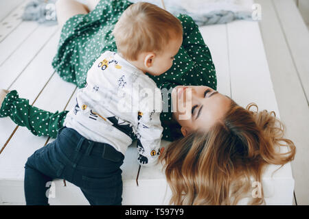 Mère assis à la maison avec peu de fils Banque D'Images