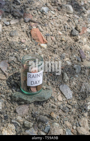 Pot d'argent / rainy day savings jar à l'extérieur dans le soleil. Métaphore l'épargne personnelle, d'économiser de l'argent, l'épargne-retraite, l'épargne-retraite, l'épargne pot Banque D'Images