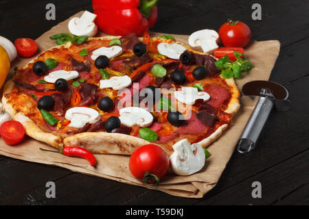 Pizza avec des ingrédients sur la table en bois Banque D'Images