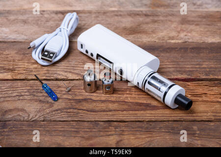 Cigarette électronique avec des bobines, l'atomiseur et têtes sur table en bois still life Banque D'Images