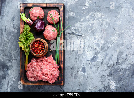 Boulettes de viande de boeuf cru vigueur-viande sur une planche à découper Banque D'Images