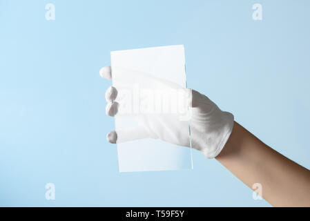 Nouvelles fonctionnalités de recherche en verre ou en plastique, hand in glove holding morceau rectangulaire matière transparente Banque D'Images